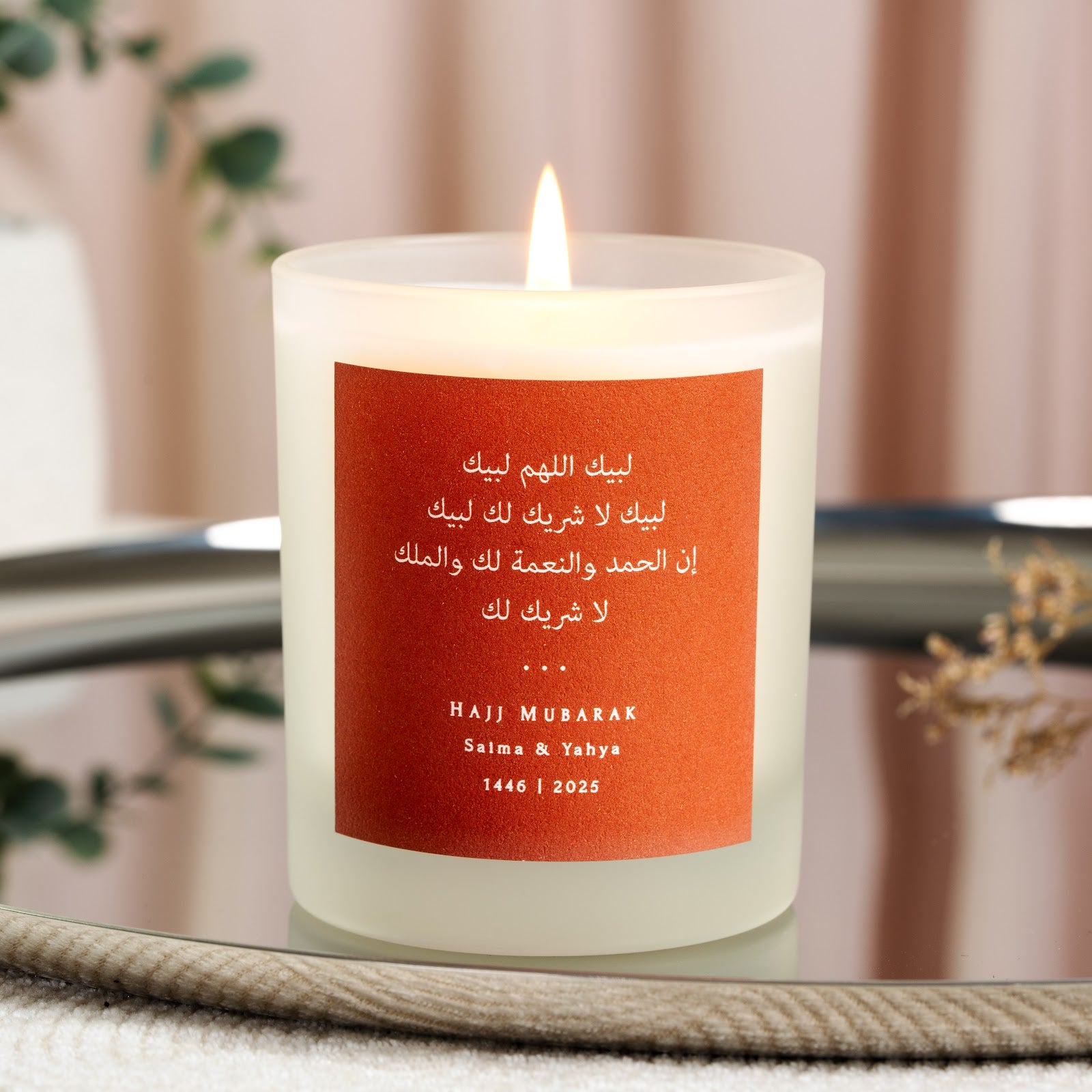 Talbiyah in white Arabic on a terracotta personalised Hajj candle above the couple's names