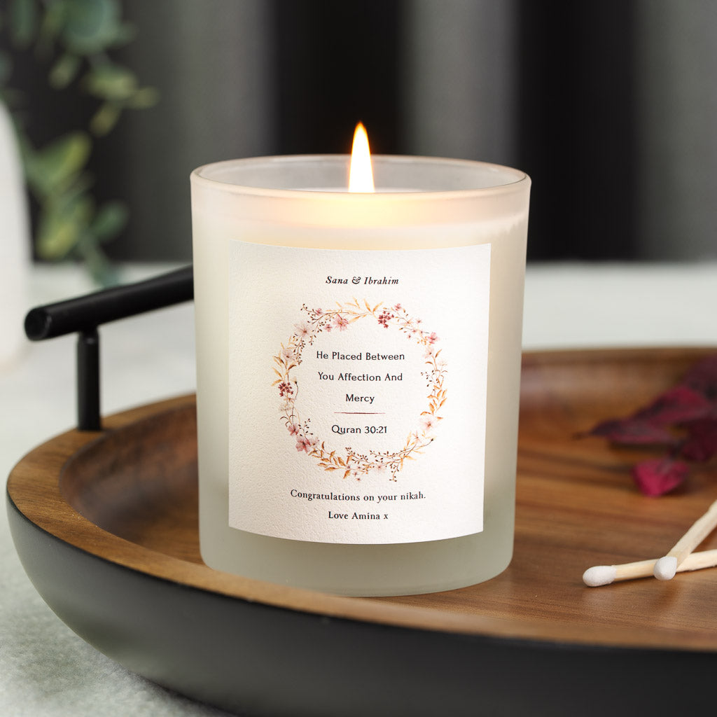 Personalised nikah candle with a wreath of pink and gold flowers encircling Surah Ar-Rum