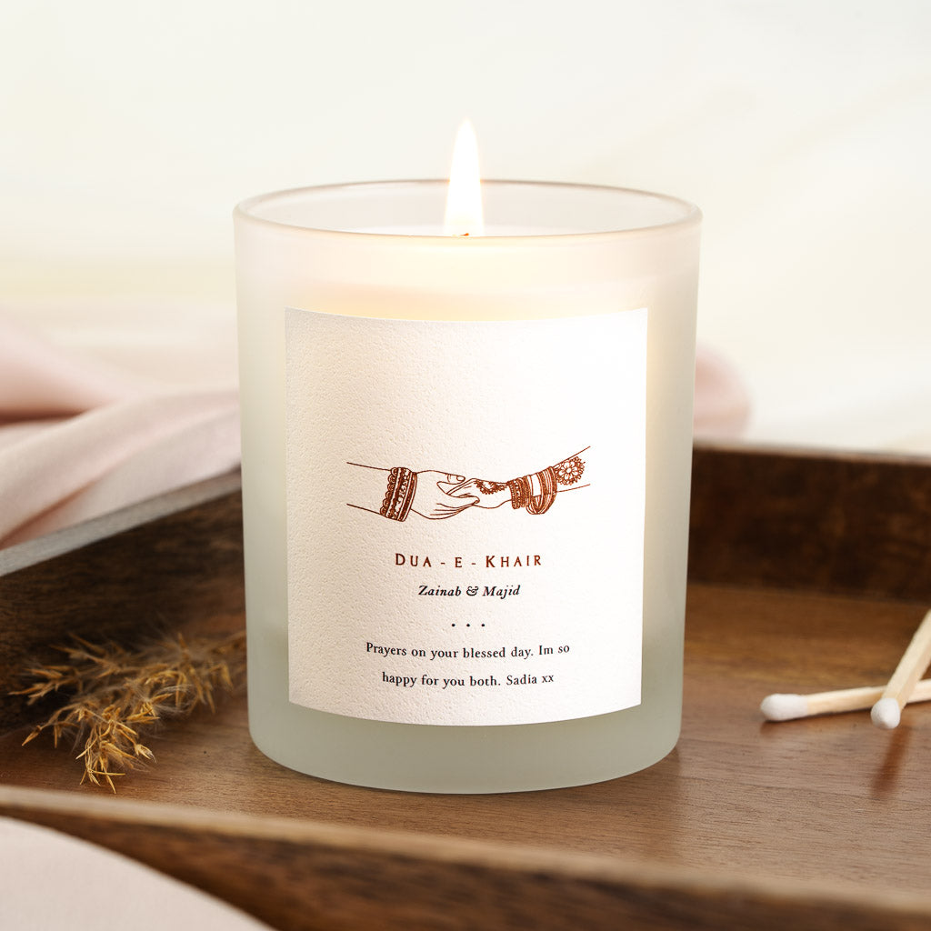 Personalised Dua-E-Khair candle with two bangled henna-patterned hands meeting at the centre