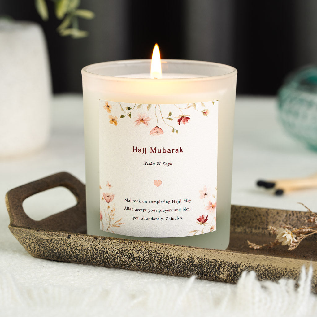 Pink, red and green wildflowers along the edges of a personalised Hajj candle label