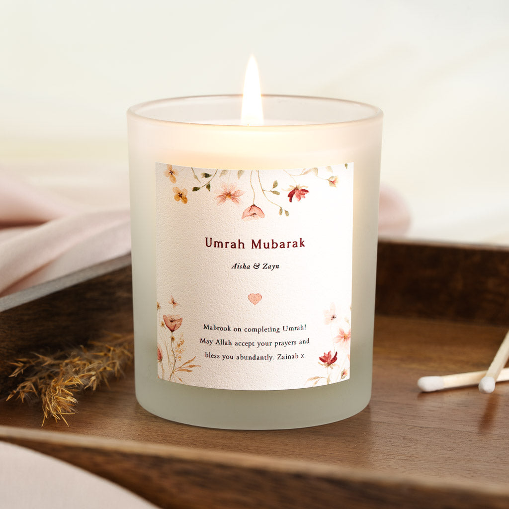 Pink, red and green wildflowers along the edges of a personalised Umrah candle label