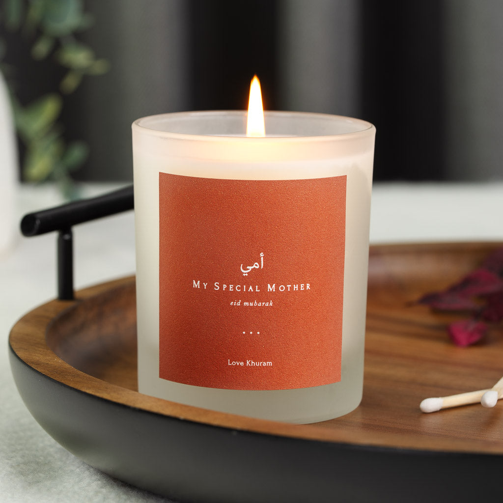 Personalised Eid candle with white Arabic script on a solid burnt orange label