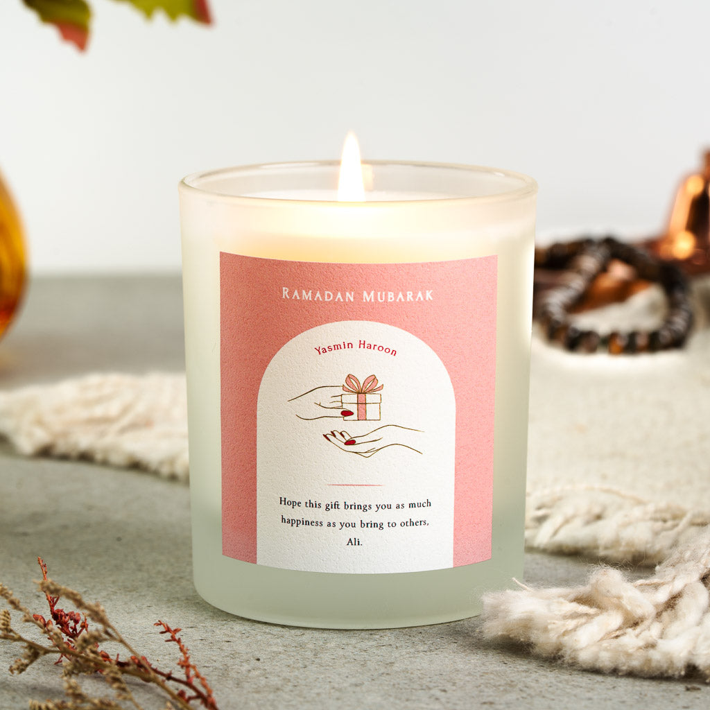 Gift illustration in a white arch on soft pink on a personalised Ramadan Mubarak candle