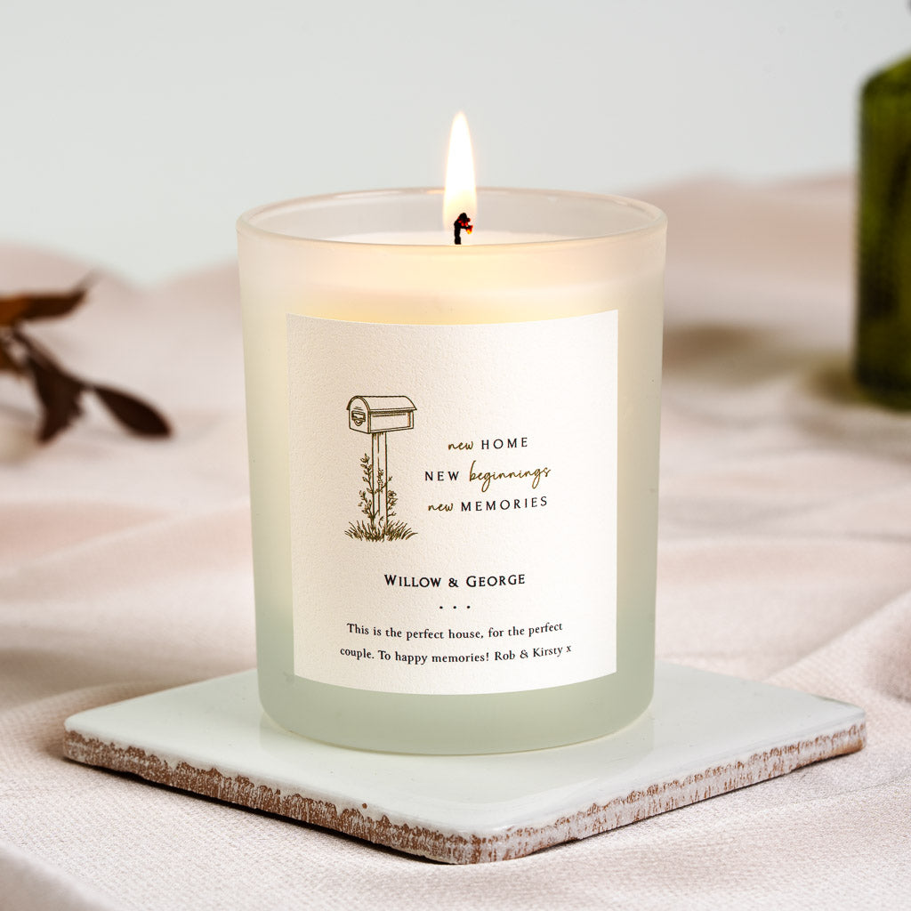 Illustrated mailbox beside a three-line heading on a personalised new home candle label