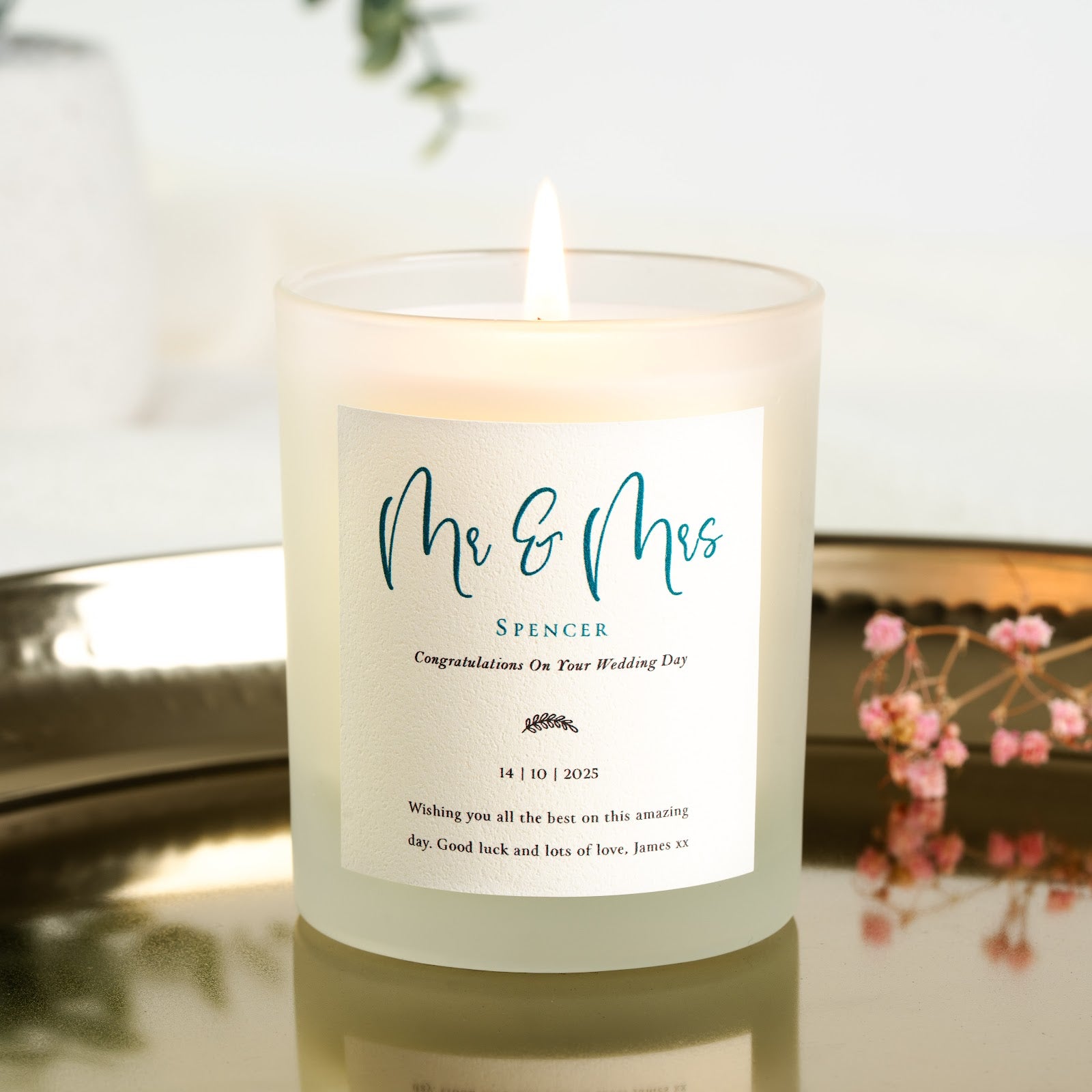 Mr and Mrs in deep teal script above a laurel sprig on a personalised wedding candle label