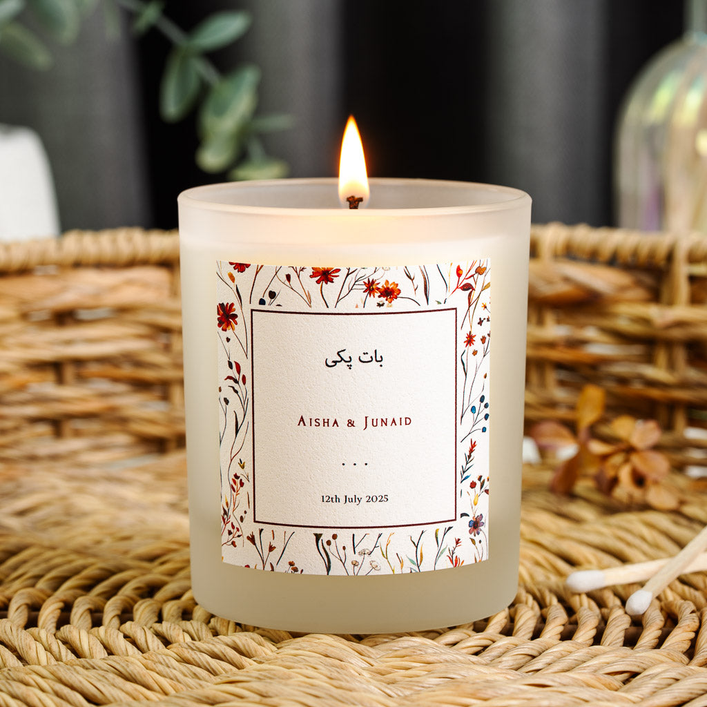 Personalised nikah candle with pressed red and blue wildflowers framing a white centre