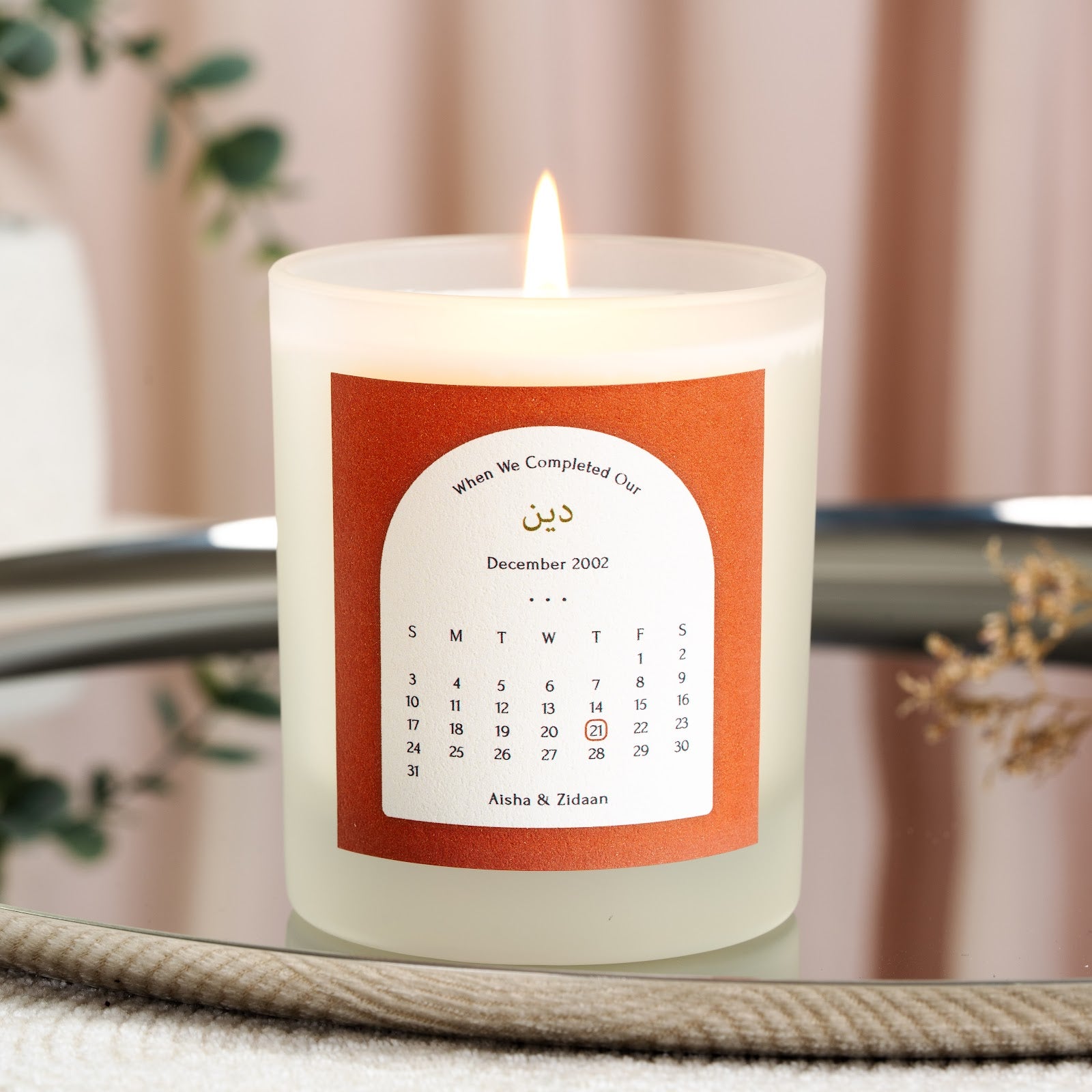 Gold-toned Arabic script on a terracotta personalised Islamic anniversary candle label