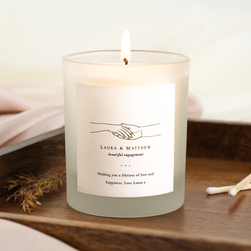 Minimal hand-drawn illustration above a short phrase on a personalised engagement candle