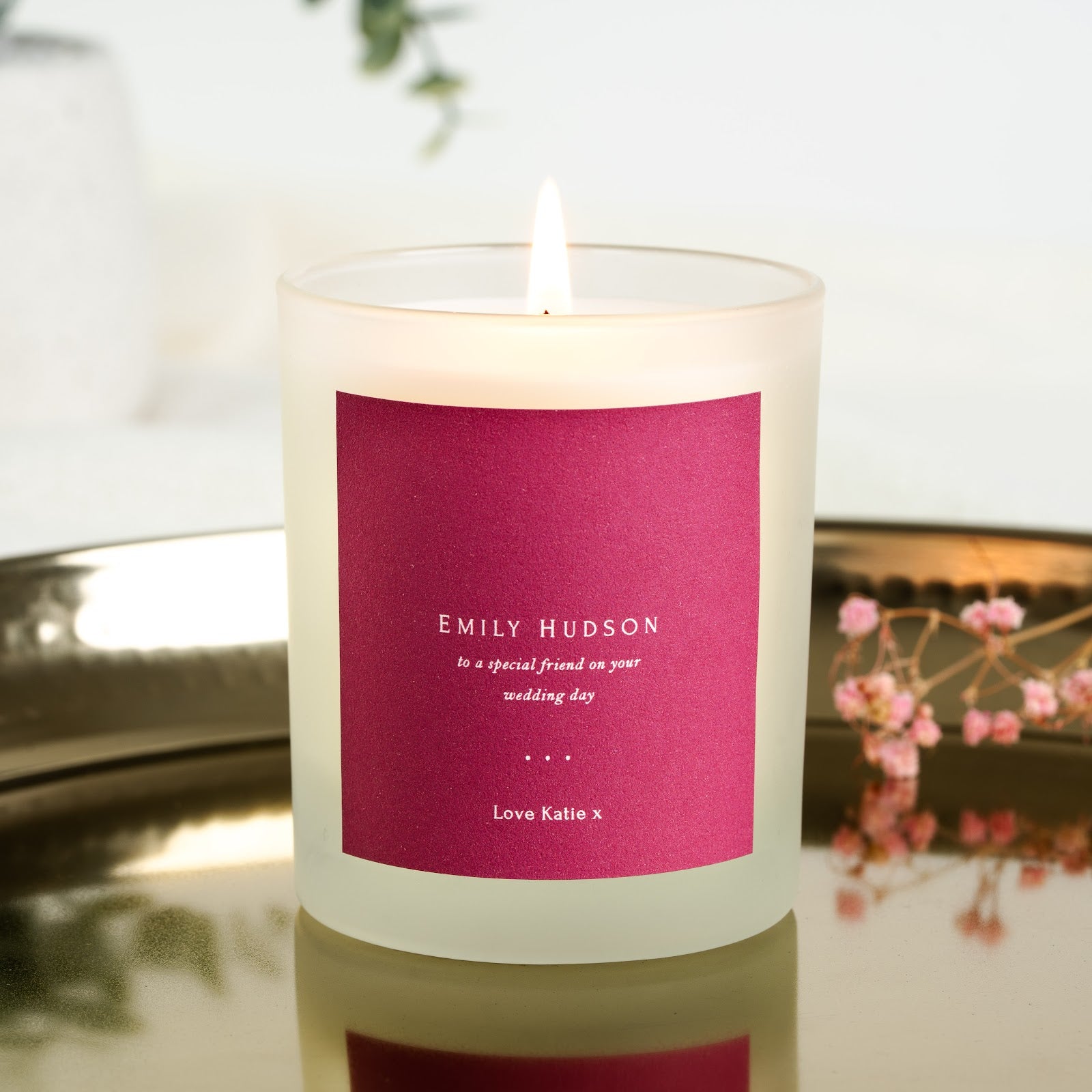 Personalised wedding candle with white capitals set against a magenta background