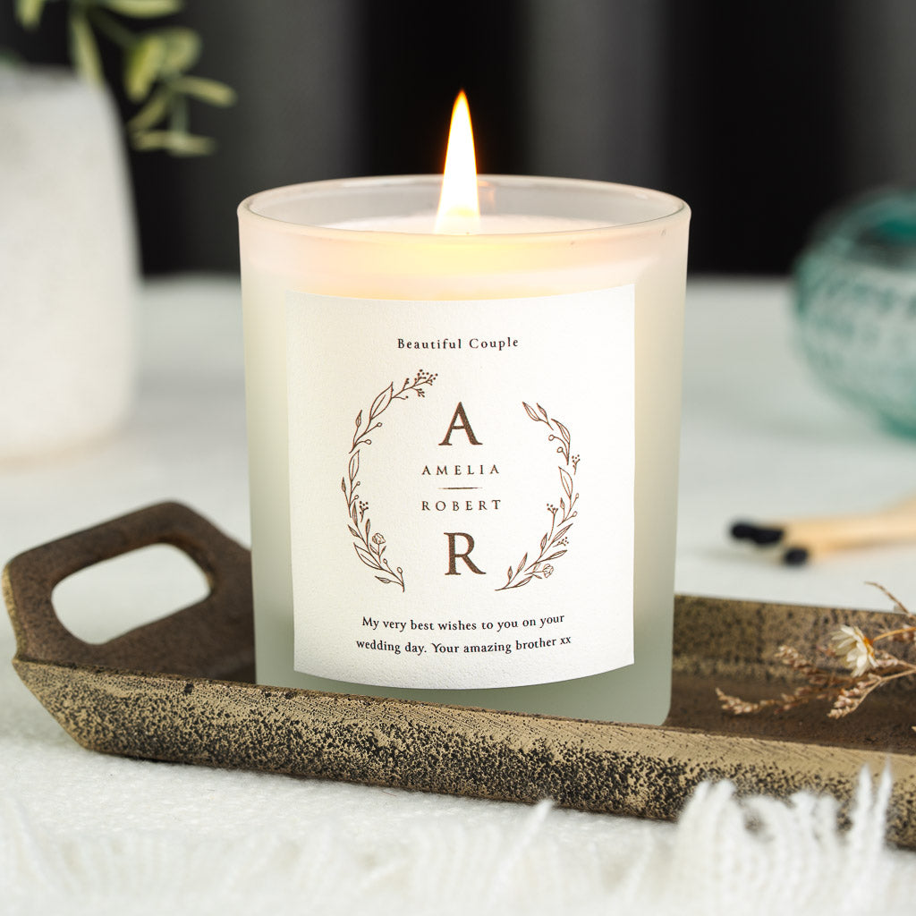 Leaf and berry wreath framing two initials on a personalised beautiful couple wedding candle
