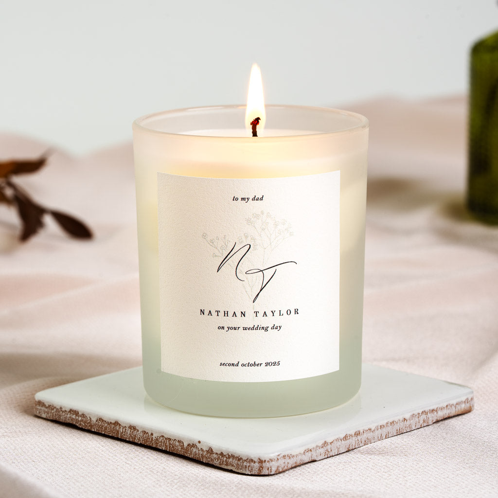 Monogram script with a line-drawn flower set behind the letters on a personalised wedding candle