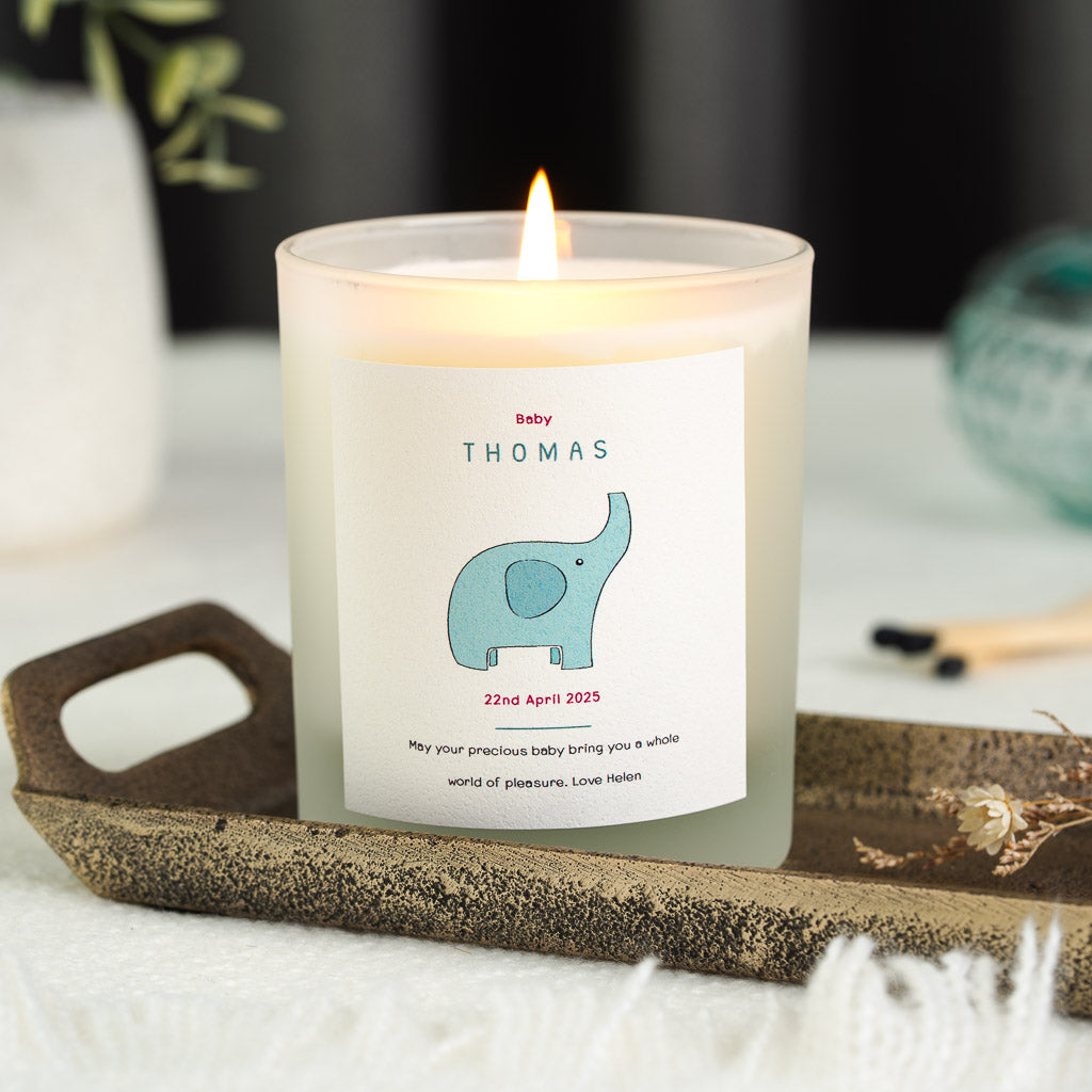Personalised new baby candle with a pale blue elephant beneath the name in deep teal capitals