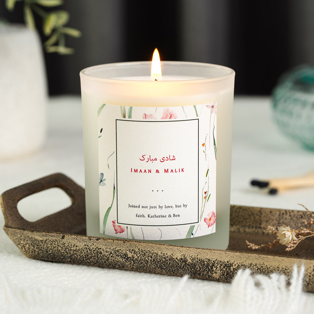 Watercolour florals bordering a thin black frame on a personalised shaadi mubarak candle