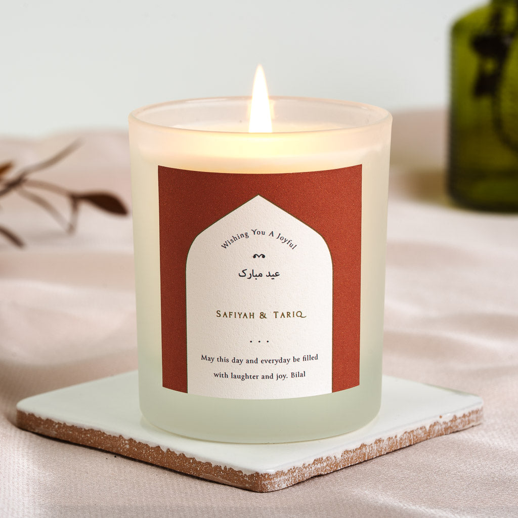 Arabic Eid Mubarak greeting above the couple's names in warm tones on a personalised candle