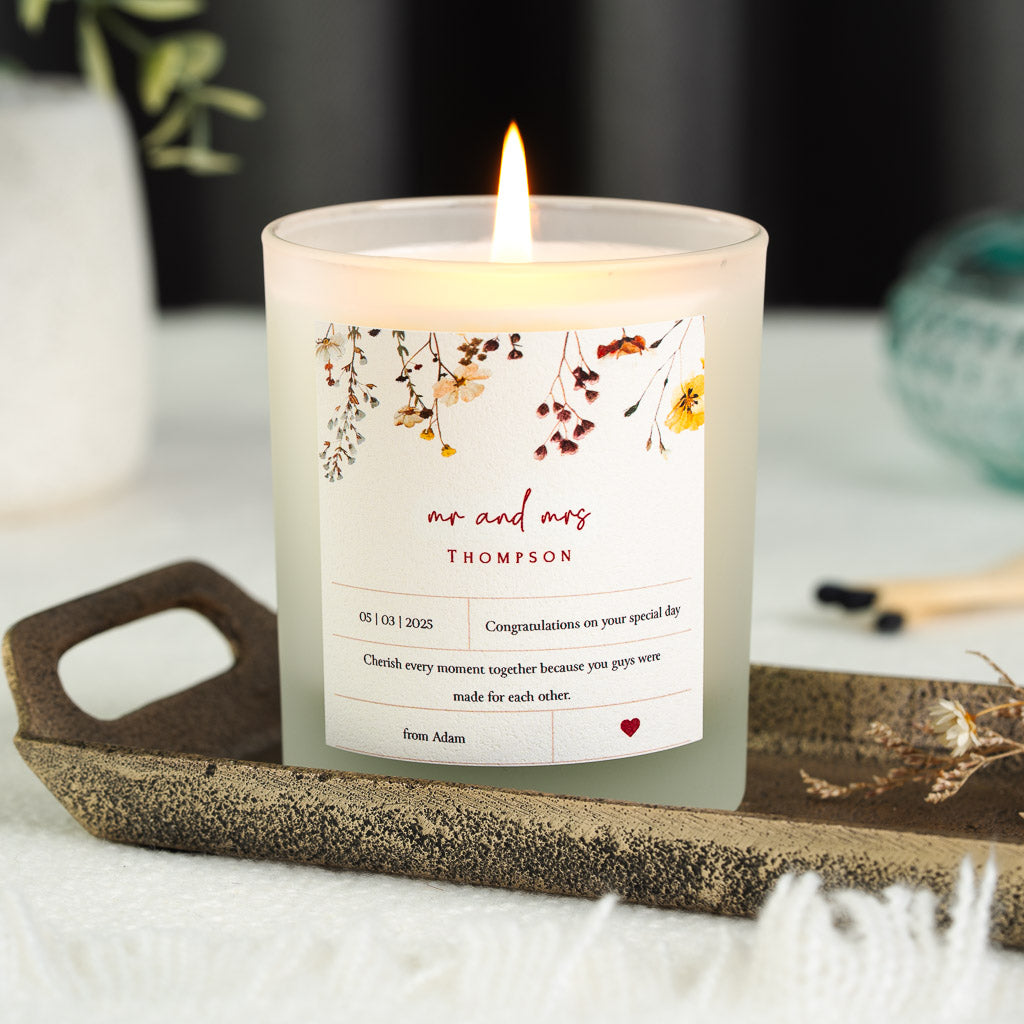 Personalised wedding candle with pressed flowers above mr and mrs in red script