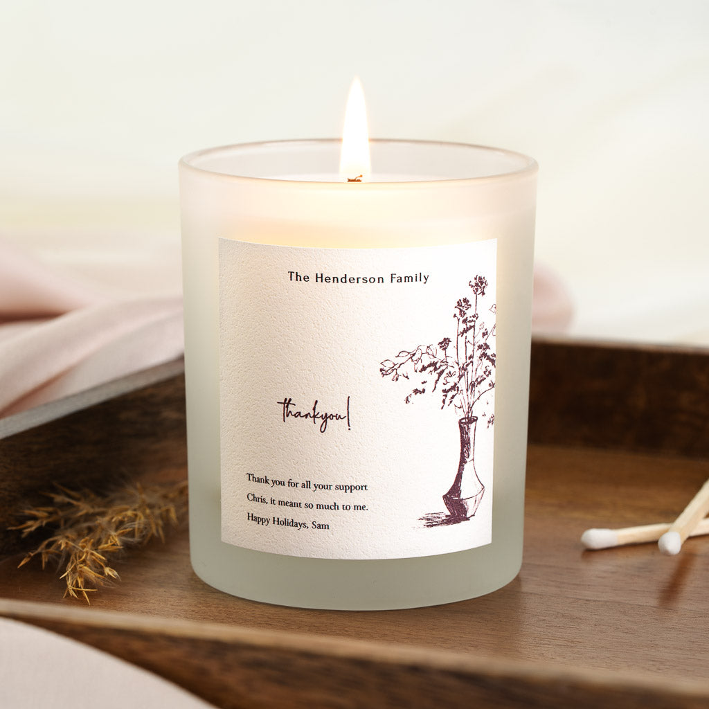 Sketched vase of wildflowers beside loose script on a personalised thank you candle label