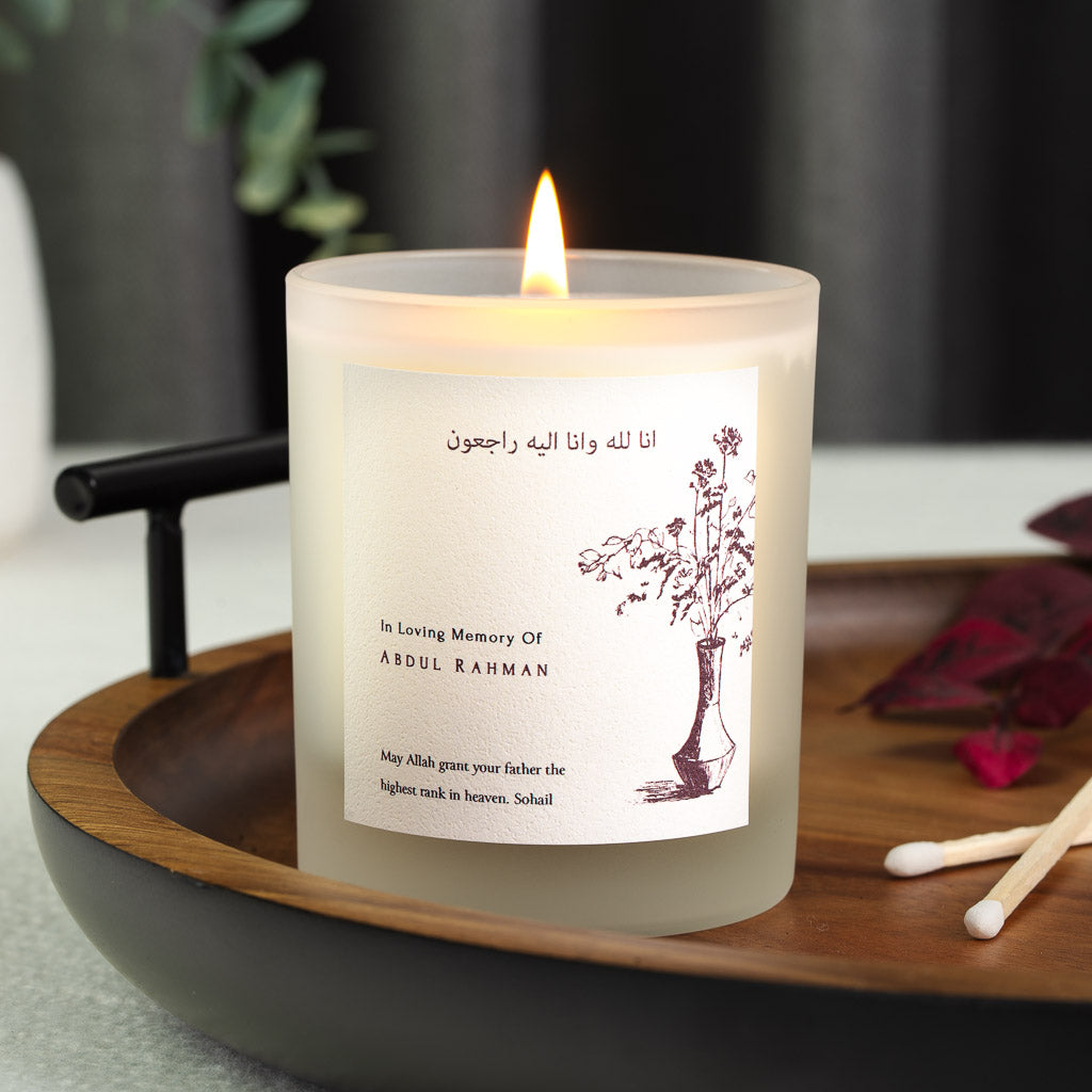 Vase of branches in deep red ink beside Surah Al-Baqarah on a personalised memorial candle