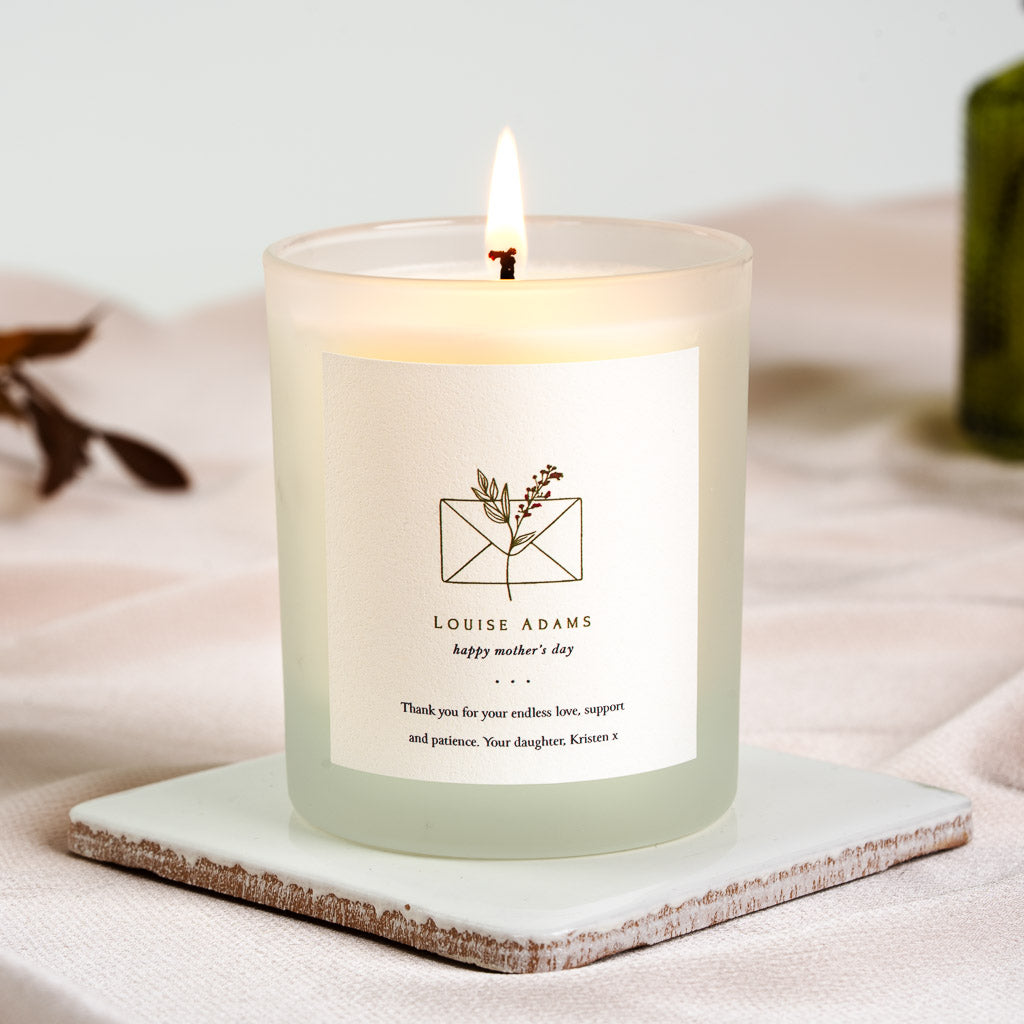 Gold line envelope and botanical sprig on a personalised Mother's Day candle label