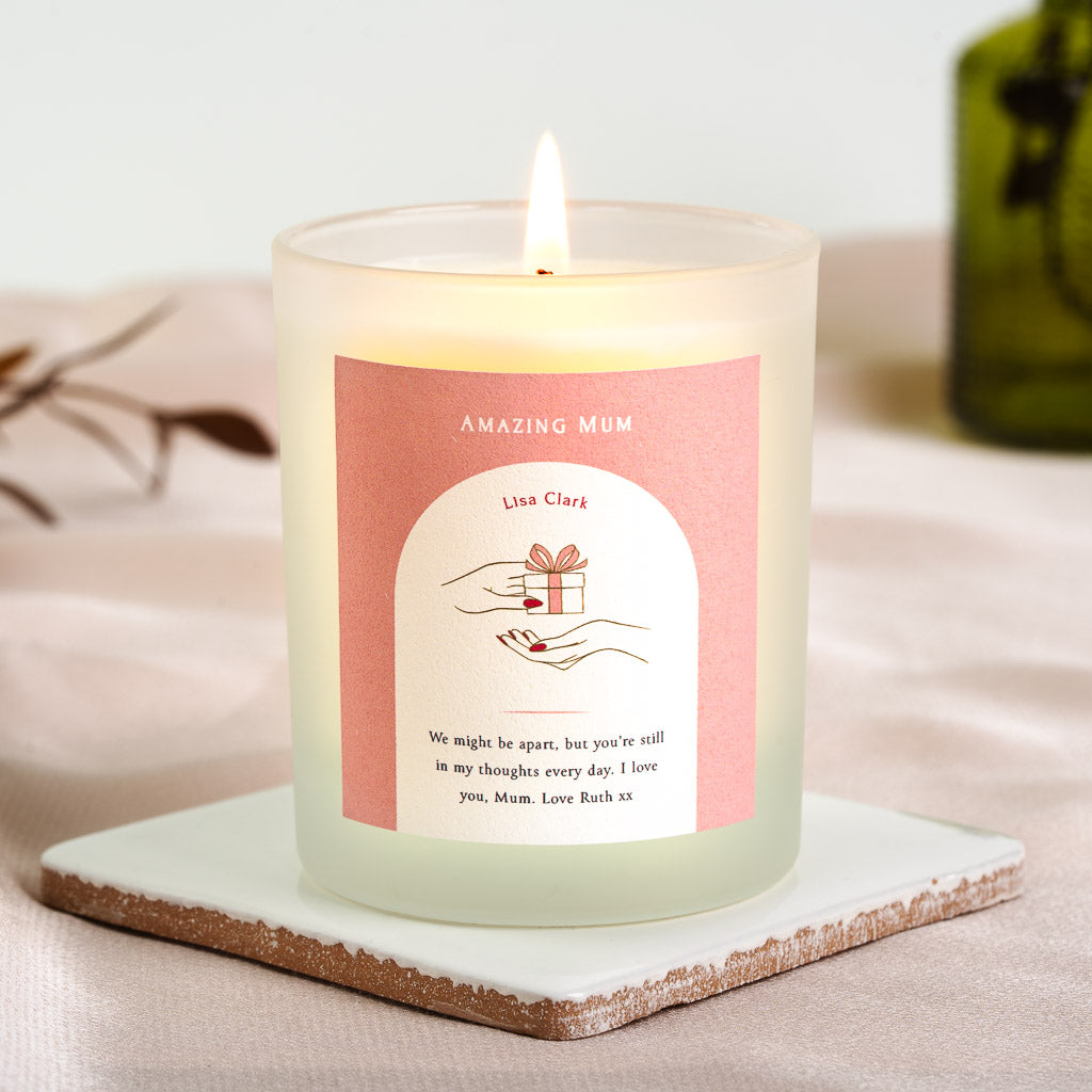 White arch on solid pink holding a gift-giving illustration on a personalised candle