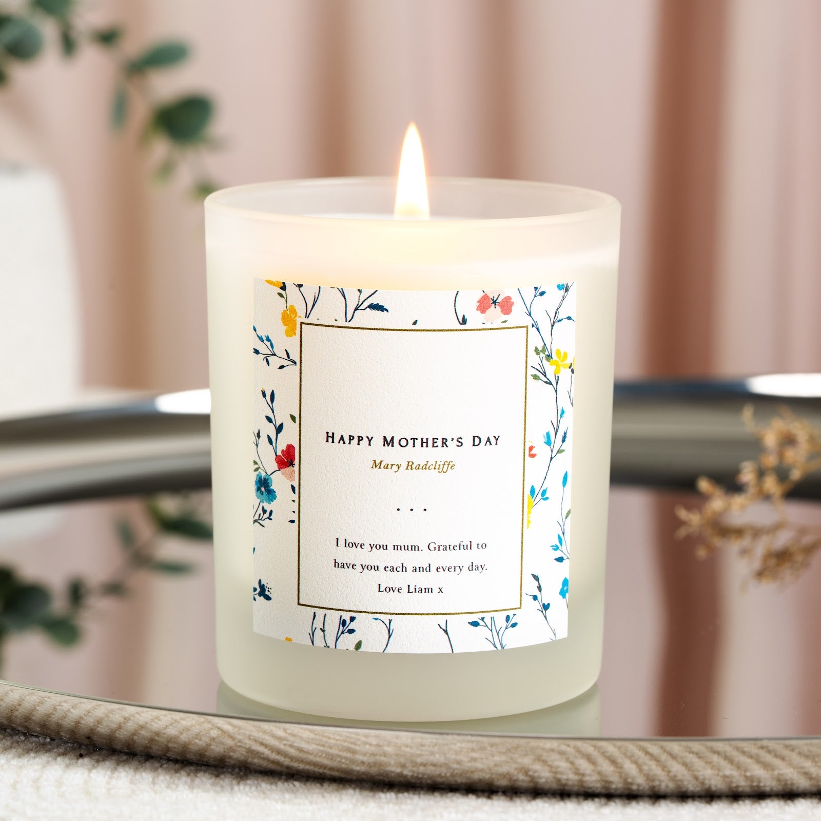 Mixed blue and red florals around a gold frame on a personalised Mother's Day candle