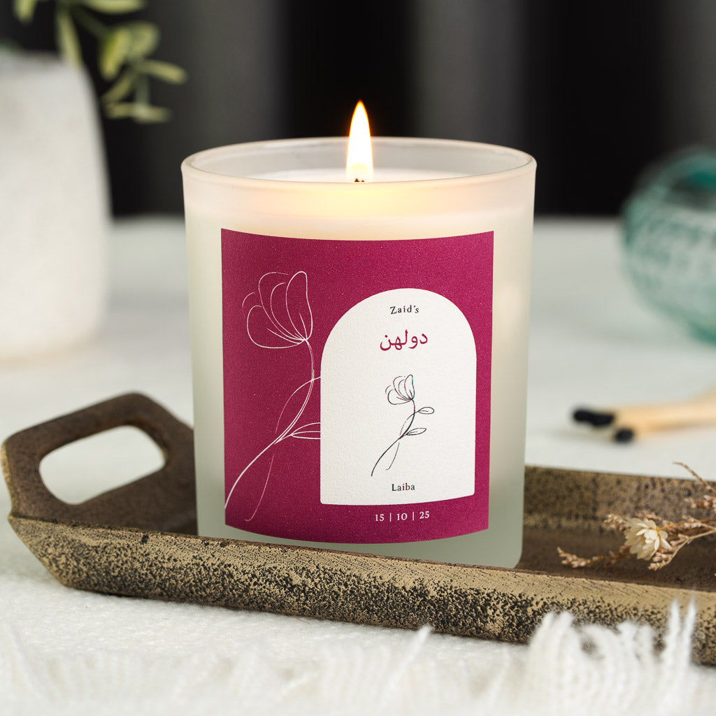 Hand-drawn flower beside a white arch on a deep magenta personalised Islamic wedding candle