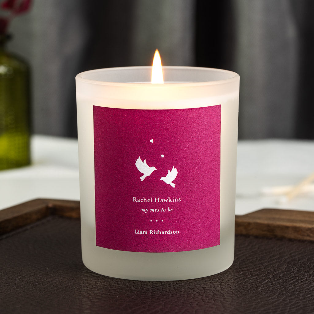 Two white doves and small hearts on a deep pink personalised wedding candle label