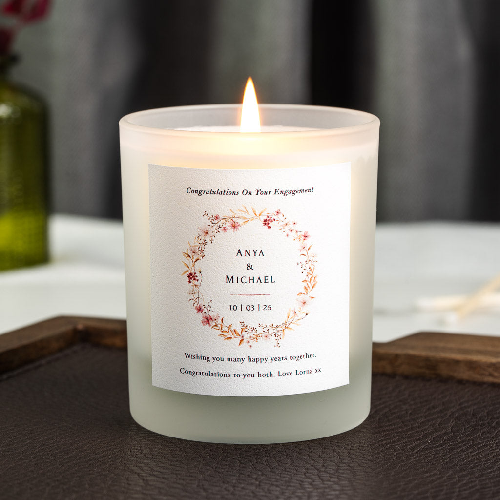 Floral wreath framing the couple's names and date on a personalised engagement candle