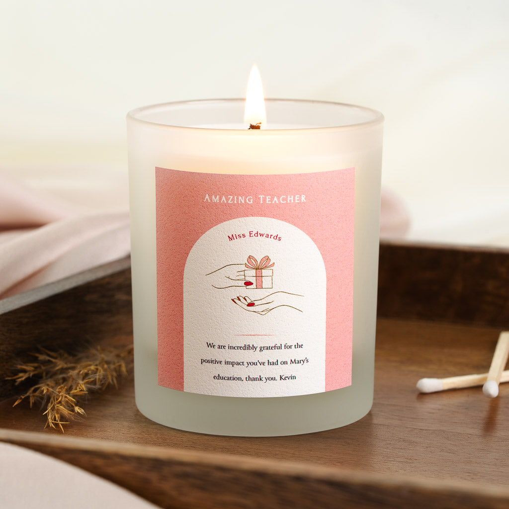 Personalised teacher candle with two hands exchanging a wrapped gift on coral