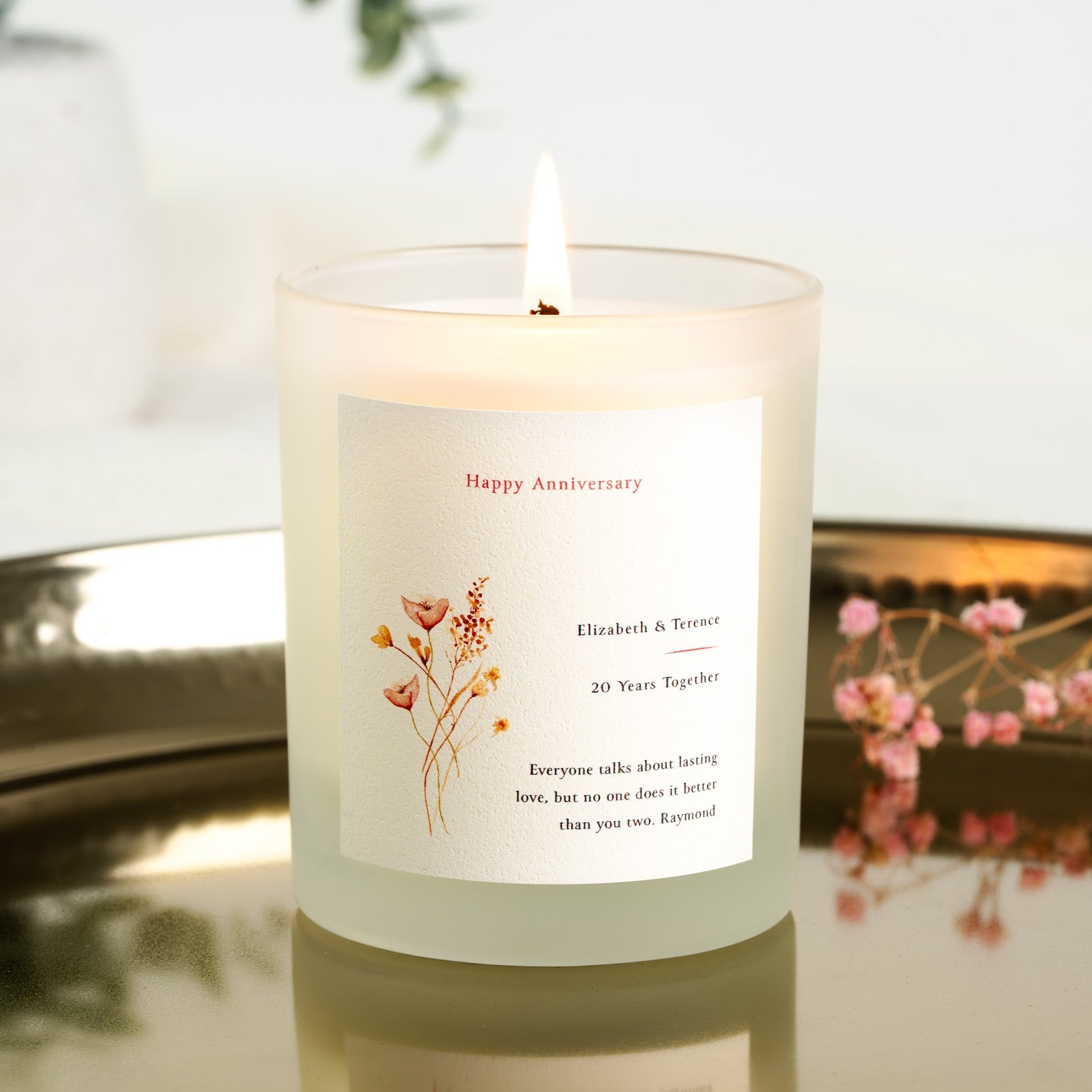 Wildflower sketch beneath a red script heading on a personalised anniversary candle label