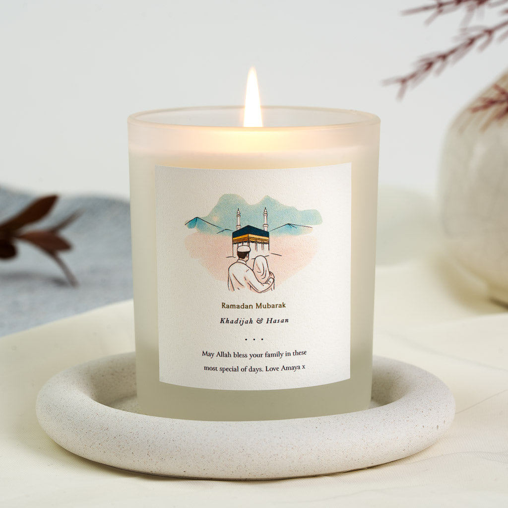 Watercolour couple facing the Kaaba in soft blue and peach on a personalised Ramadan candle