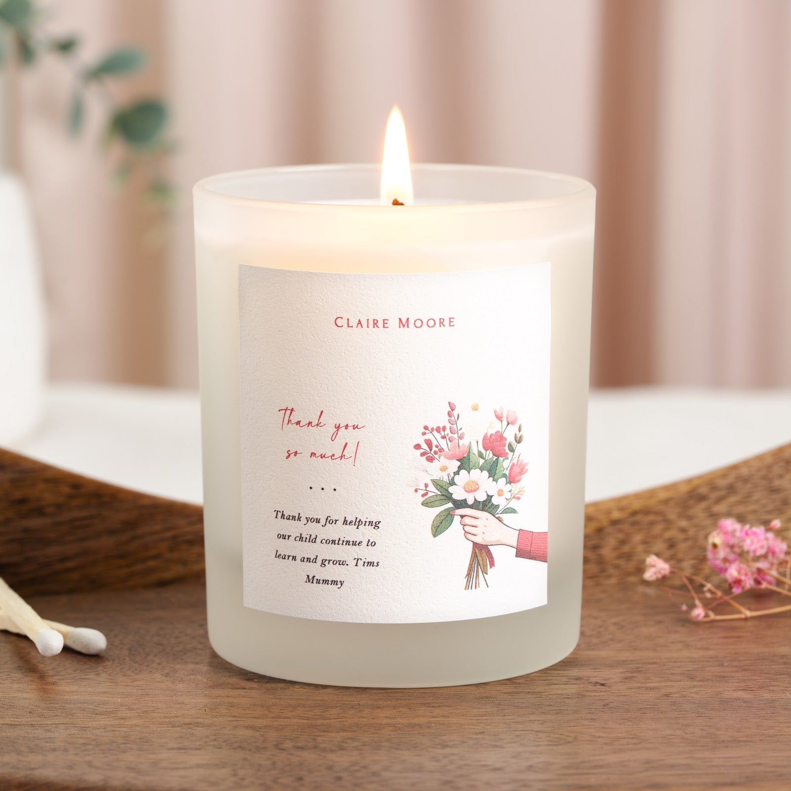Personalised thank you candle with a bouquet illustration beside red script lettering