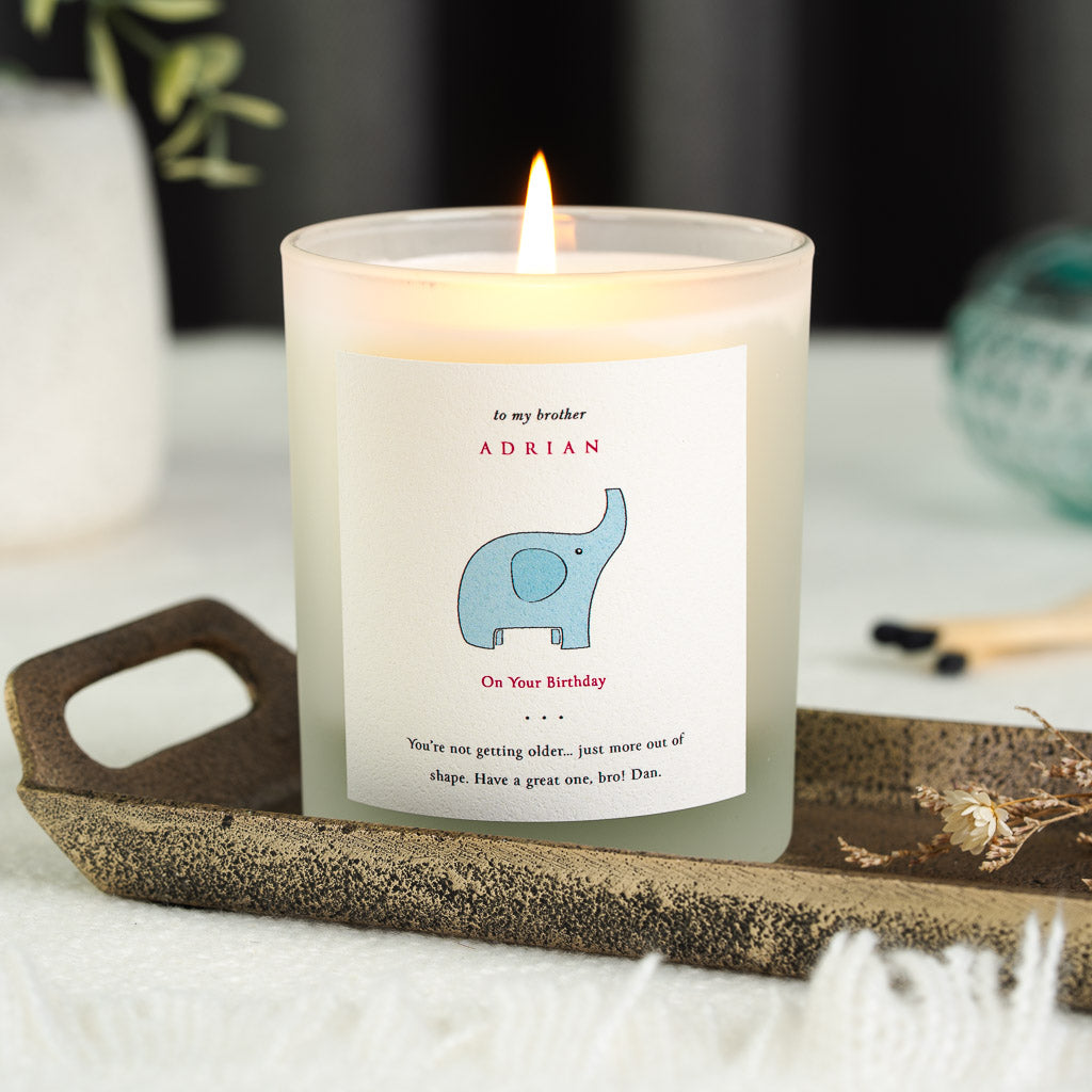 Red capital lettering set above an elephant illustration on a personalised birthday candle
