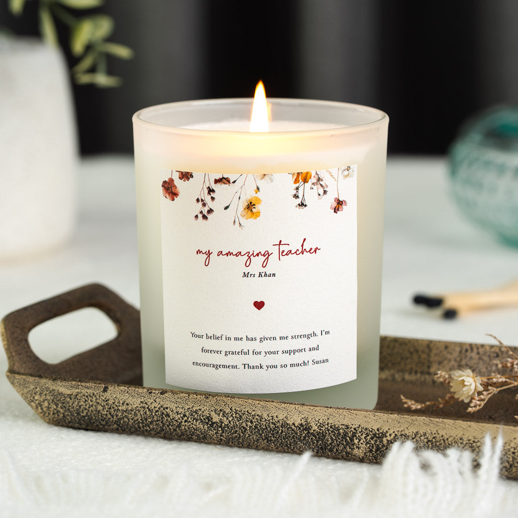 Personalised teacher candle with autumnal pressed flowers hanging across the top