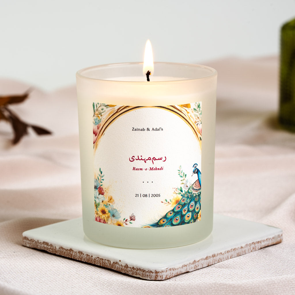 Personalised Rasm-e-Mehndi candle with a watercolour peacock beneath a gold-toned arch