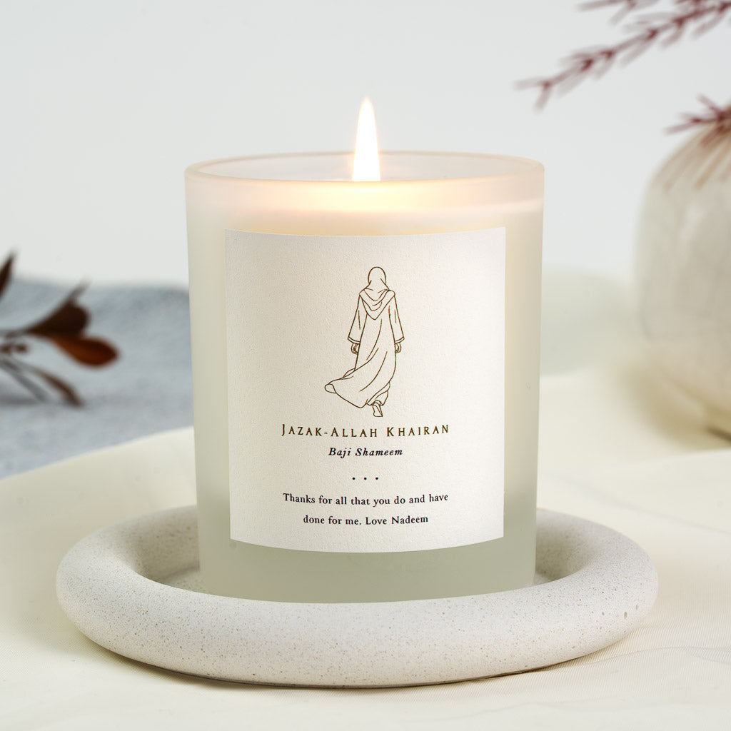 Gold outline figure in a hijab and abaya walking away on a personalised thank you candle