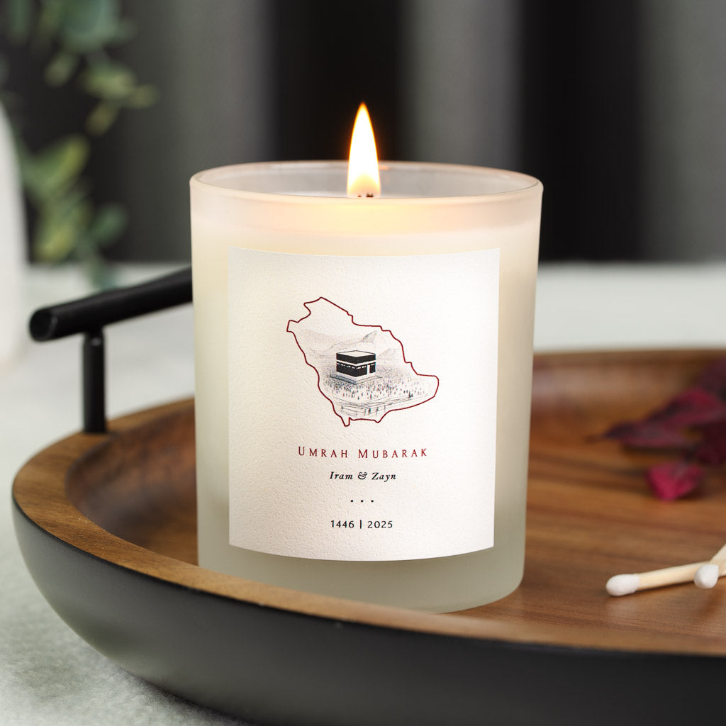Red-outlined map of Saudi Arabia holding a pencil-sketched Kaaba on a personalised Umrah candle