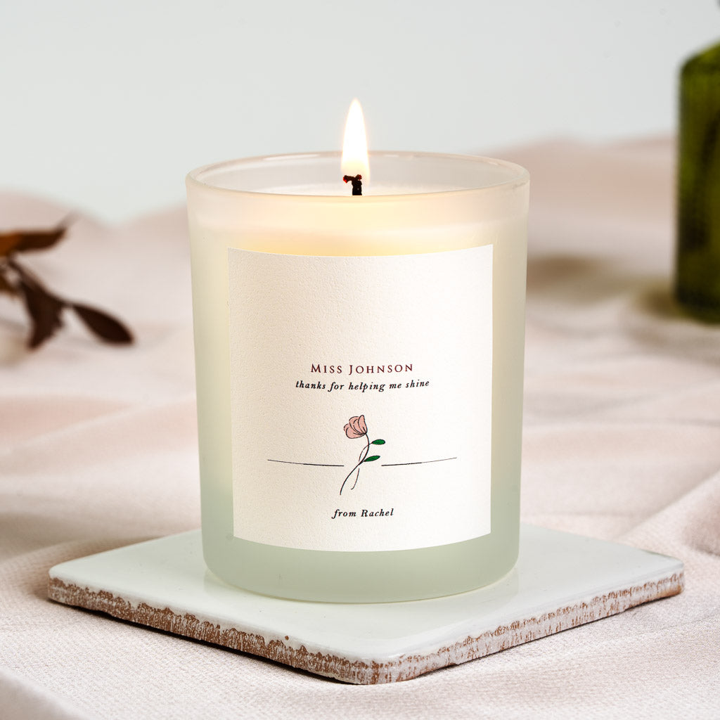 Personalised teacher candle with a soft pink and green rose beneath a horizontal rule