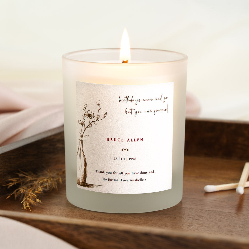 Personalised birthday candle with a floral vase beside script lettering at the top
