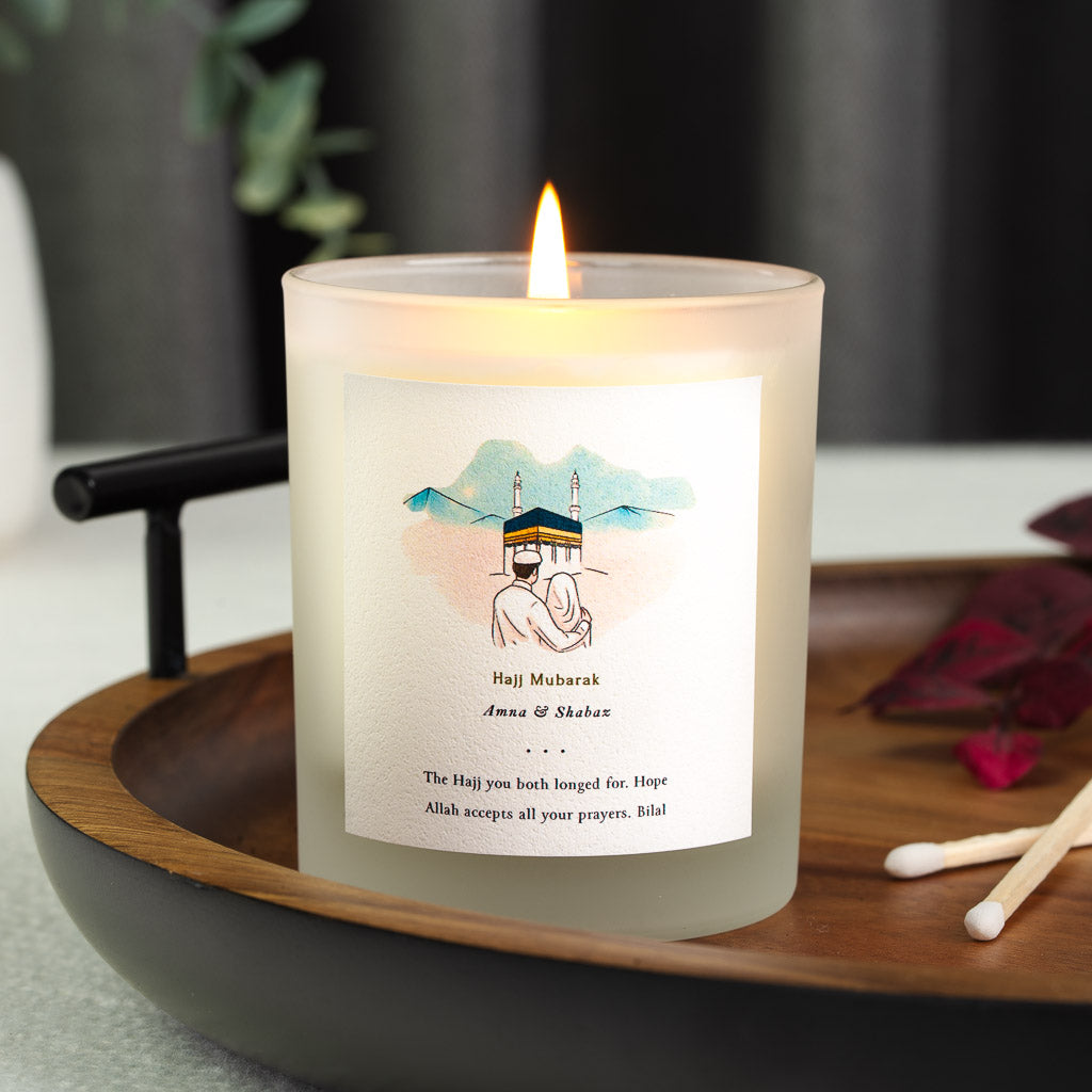 Personalised Hajj mubarak candle with gold-toned script above a watercolour illustration