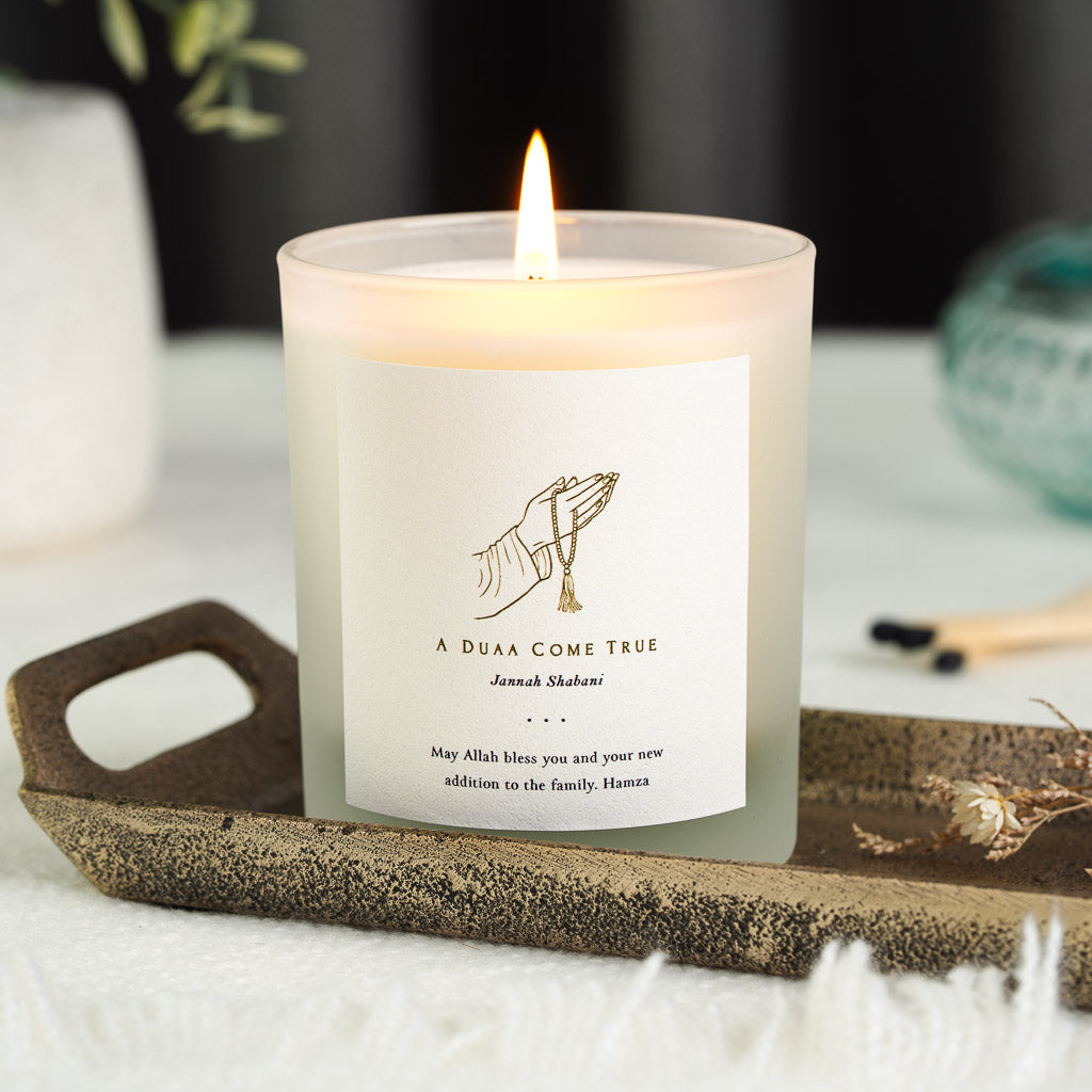 Praying hands and tasbih beads in fine gold linework on a personalised new baby candle