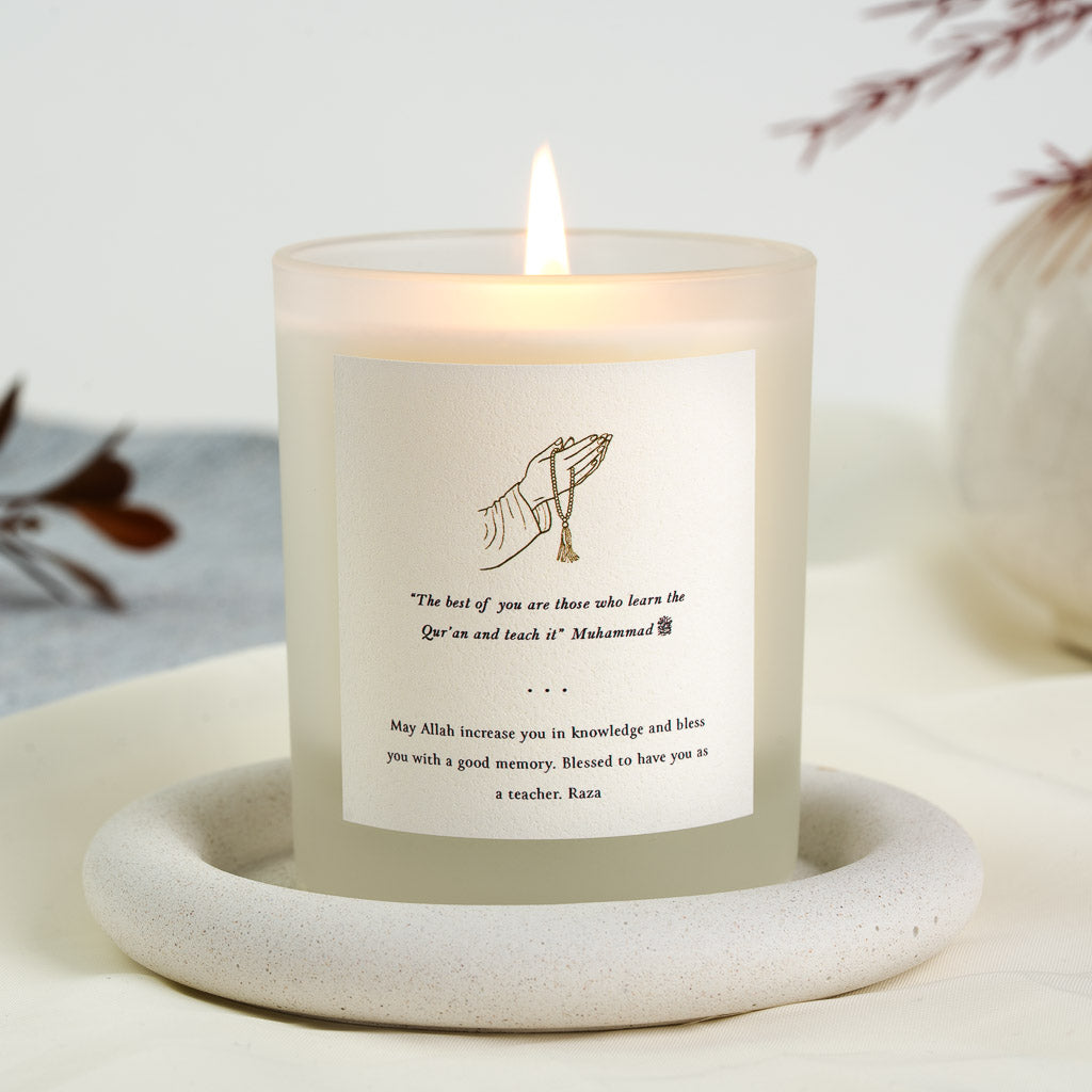 Personalised Quran teacher candle with prayer beads above a hadith on teaching