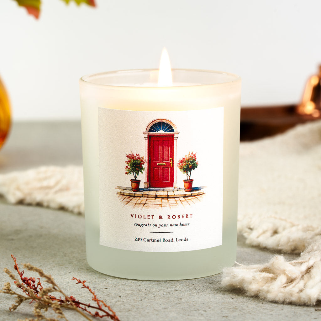 Personalised new home candle with a full-colour doorway above the names in deep red