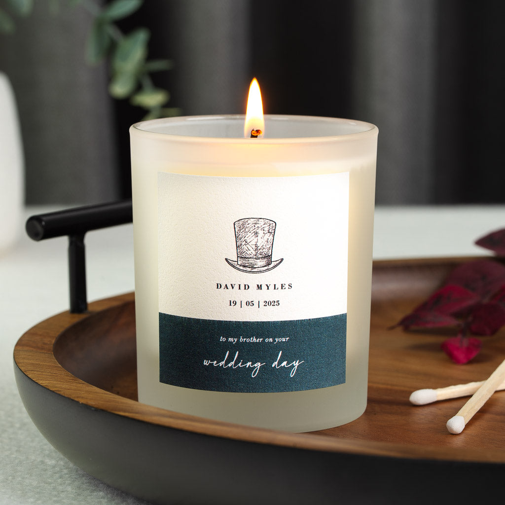 Top hat illustration above a deep teal band on a personalised wedding candle label