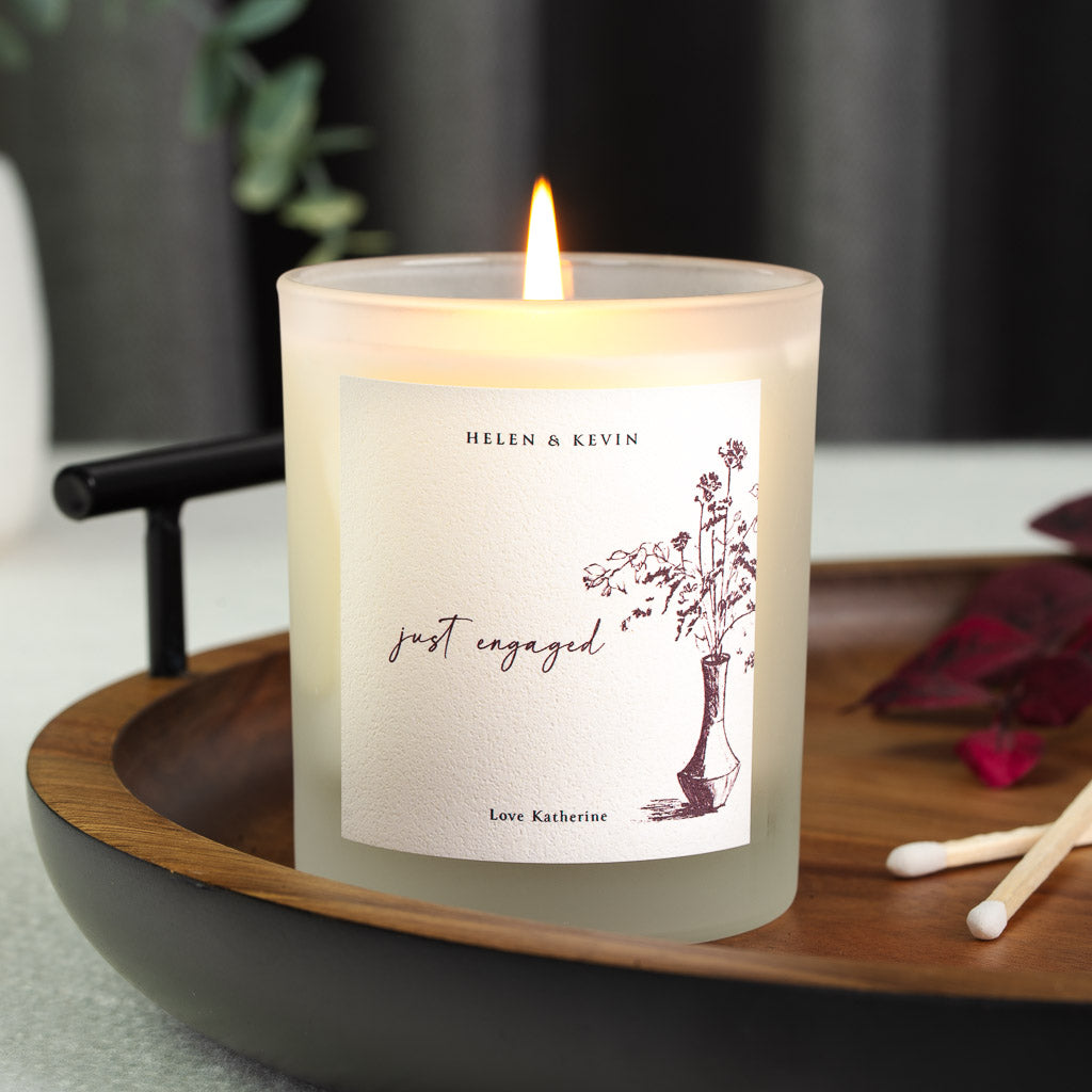 Vintage vase illustration beneath just engaged script on a personalised engagement candle