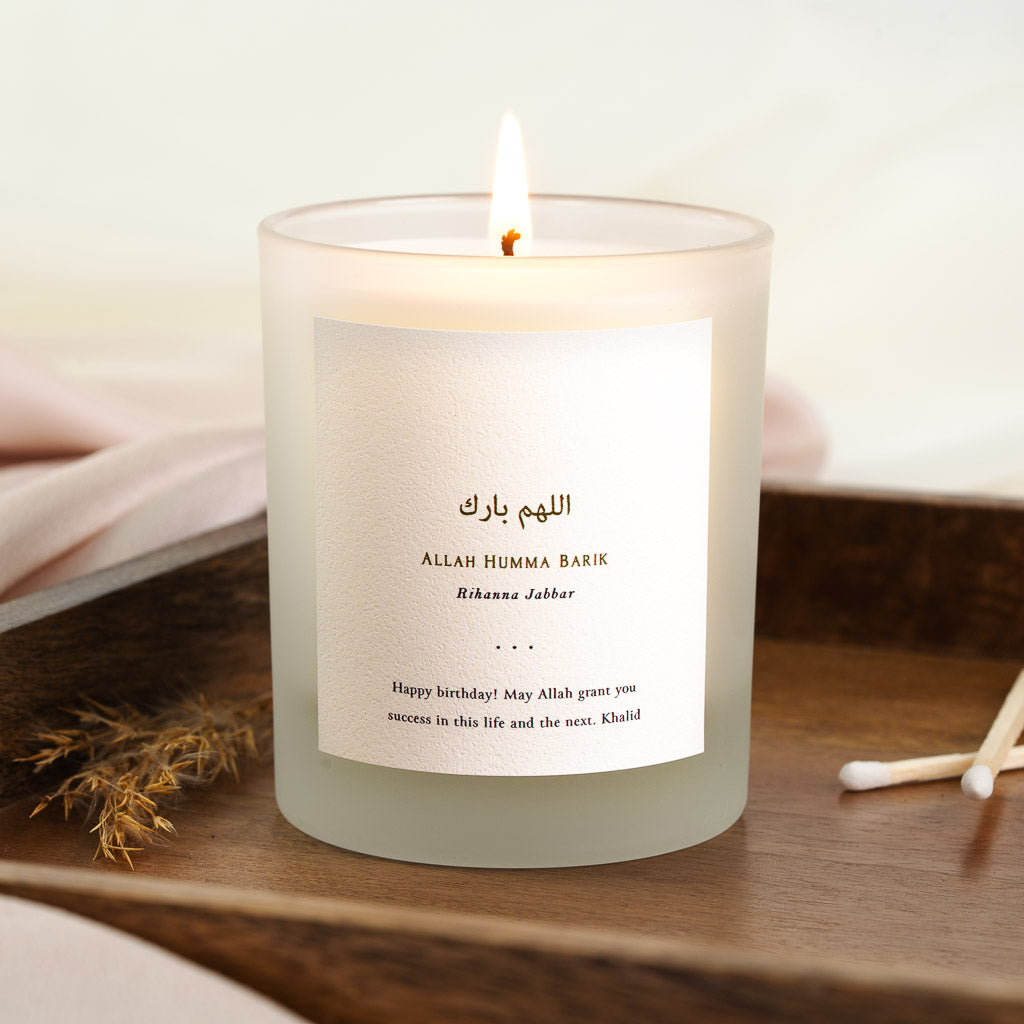 Gold-toned Arabic calligraphy above its transliteration on a personalised birthday candle