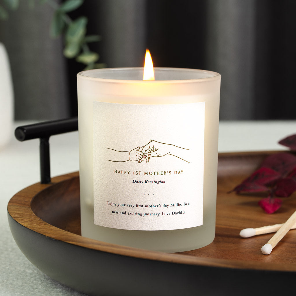 Personalised first Mother's Day candle with an adult and baby hand touching fingertips