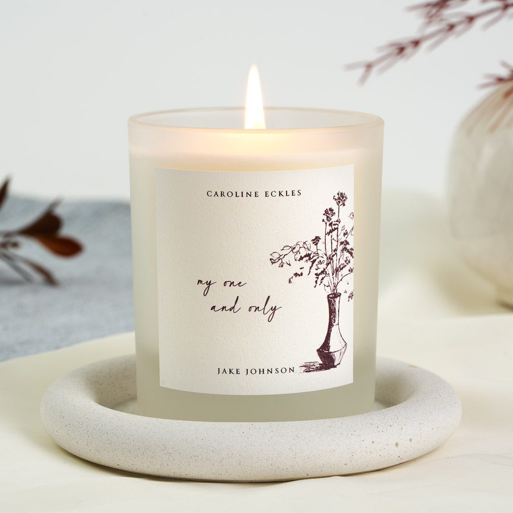 Brown ink vase of wildflowers beside red script on a personalised wedding morning candle