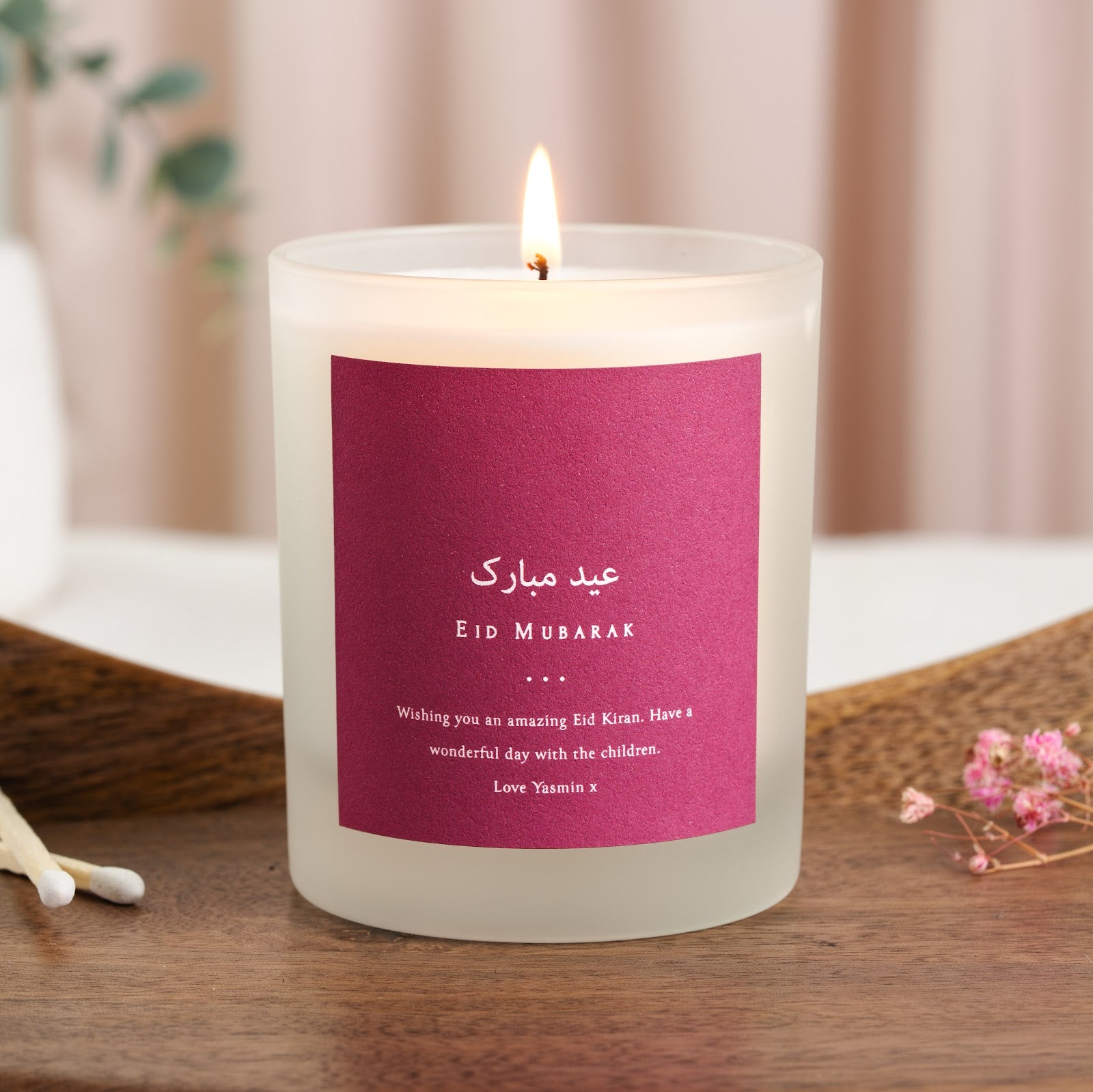 Arabic Eid Mubarak greeting and its translation on a solid magenta personalised candle